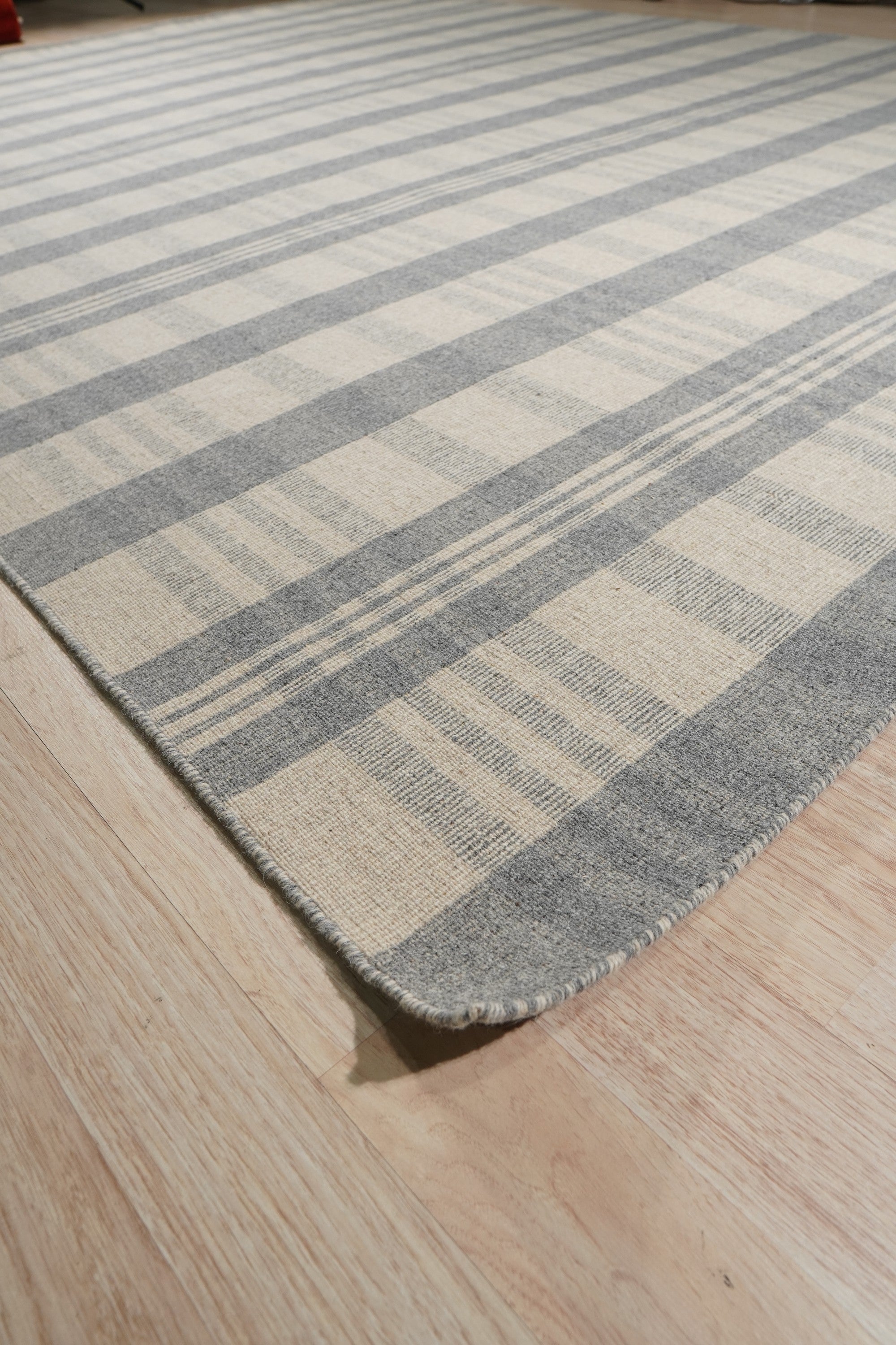 Handcrafted Vibrant Gray Flatweave Wool Rug, a textured gray wool rug with a flatweave construction, displayed in a living room setting.