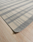 Handcrafted Vibrant Gray Flatweave Wool Rug displayed in a bright, modern living room. Gray and white geometric patterns create a contemporary feel on this flatweave wool rug, anchoring the space.