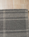 Graceful Quinn Gray Flatweave Wool Rug displayed in a bright living room setting. Its subtle gray tones and flatweave construction complement a modern, minimalist design with a light-colored sofa and coffee table.