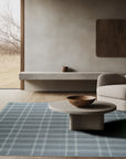 Graceful Quinn Gray Flatweave Wool Rug, a subtly textured gray wool rug with a modern, minimalist design, sits elegantly on a light wood floor, complementing the clean lines of the contemporary space.