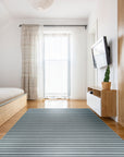 Lush Timeless Gray Flatweave Wool Rug, woven in a flatweave construction, rests on a light wood floor. Soft, diffused light highlights the rug's subtle gray tones and textured surface.