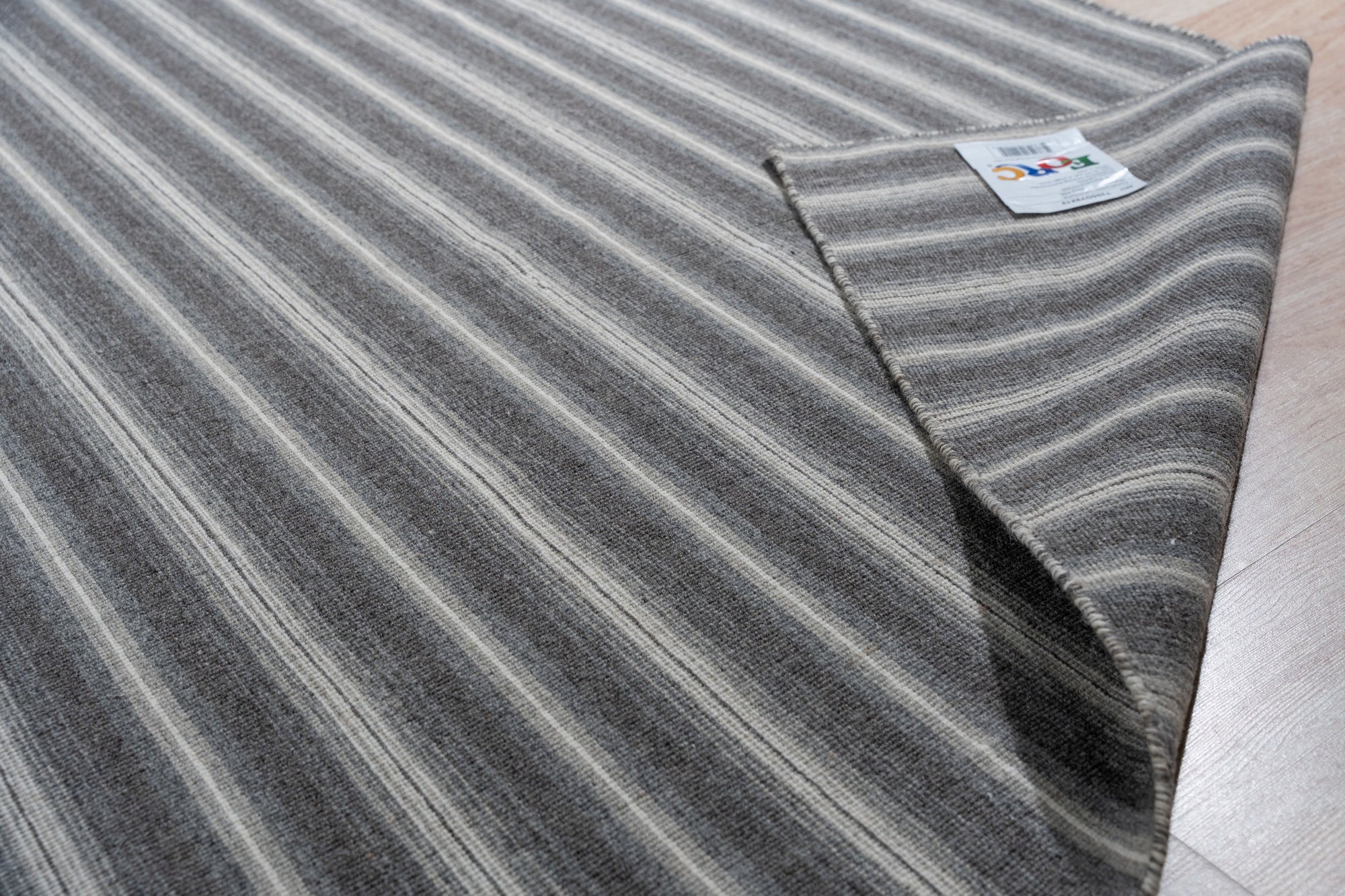 Lush Timeless Gray Flatweave Wool Rug, a subtly textured gray wool rug with a flatweave construction, displayed in a bright, modern living room setting.