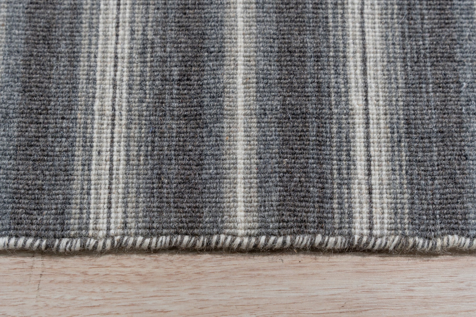 Lush Timeless Gray Flatweave Wool Rug, a sophisticated gray wool rug with a subtle pattern, displayed in a modern living room setting.