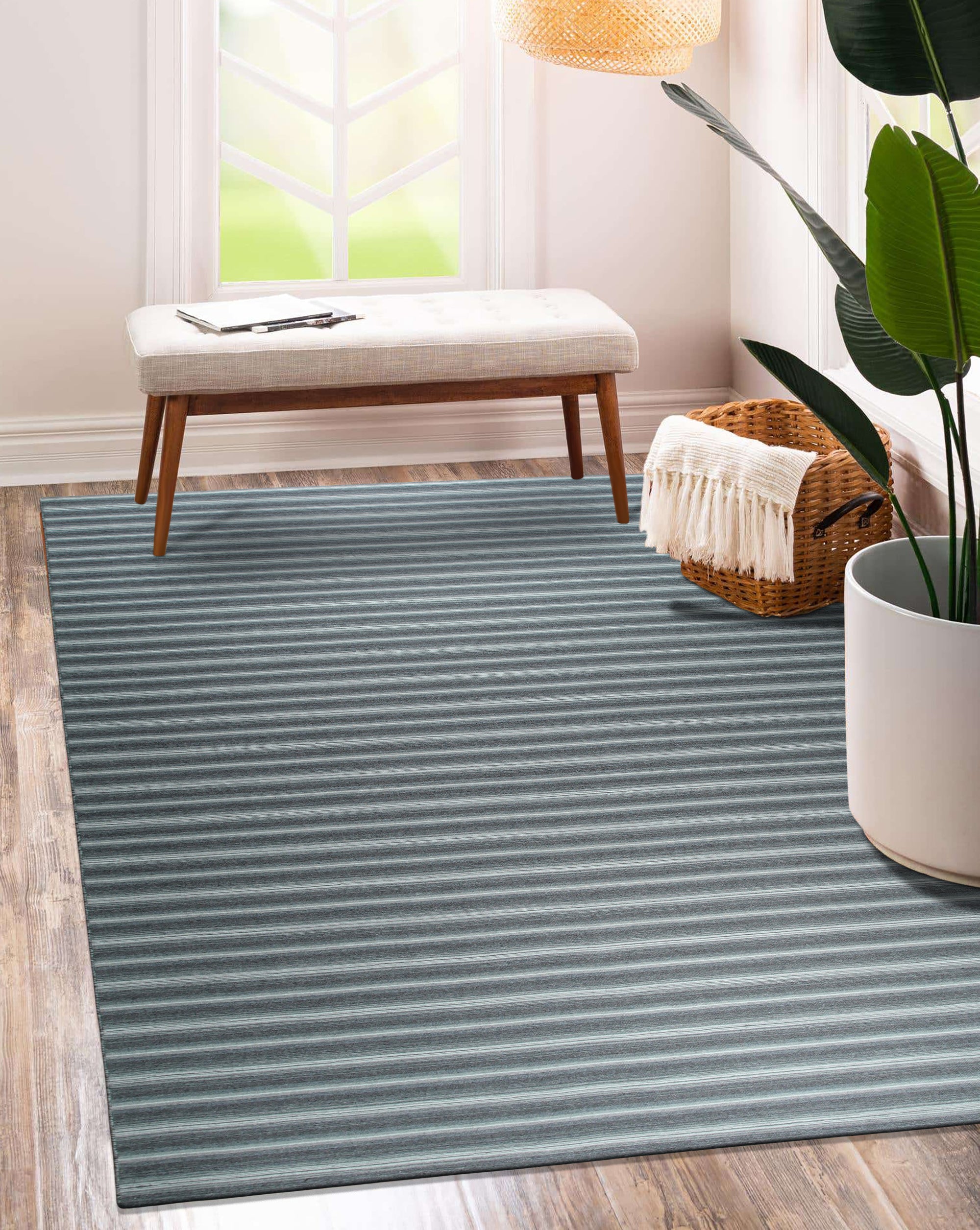 Lush Timeless Gray Flatweave Wool Rug, soft gray hues and subtle texture create a calming atmosphere in a bright, minimalist living room setting with a light wood floor.
