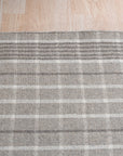 Timeless Celia Gray Flatweave Wool Rug, a muted gray flatweave wool rug subtly textured, seen in a bright, contemporary living room setting.
