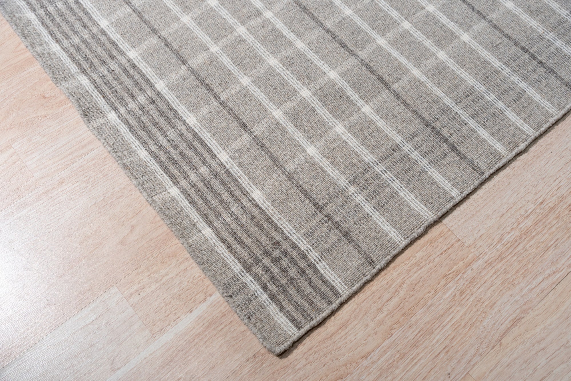 Timeless Celia Gray Flatweave Wool Rug, subtle patterns dance across soft gray wool, enhancing a bright living space with a modern, inviting texture.