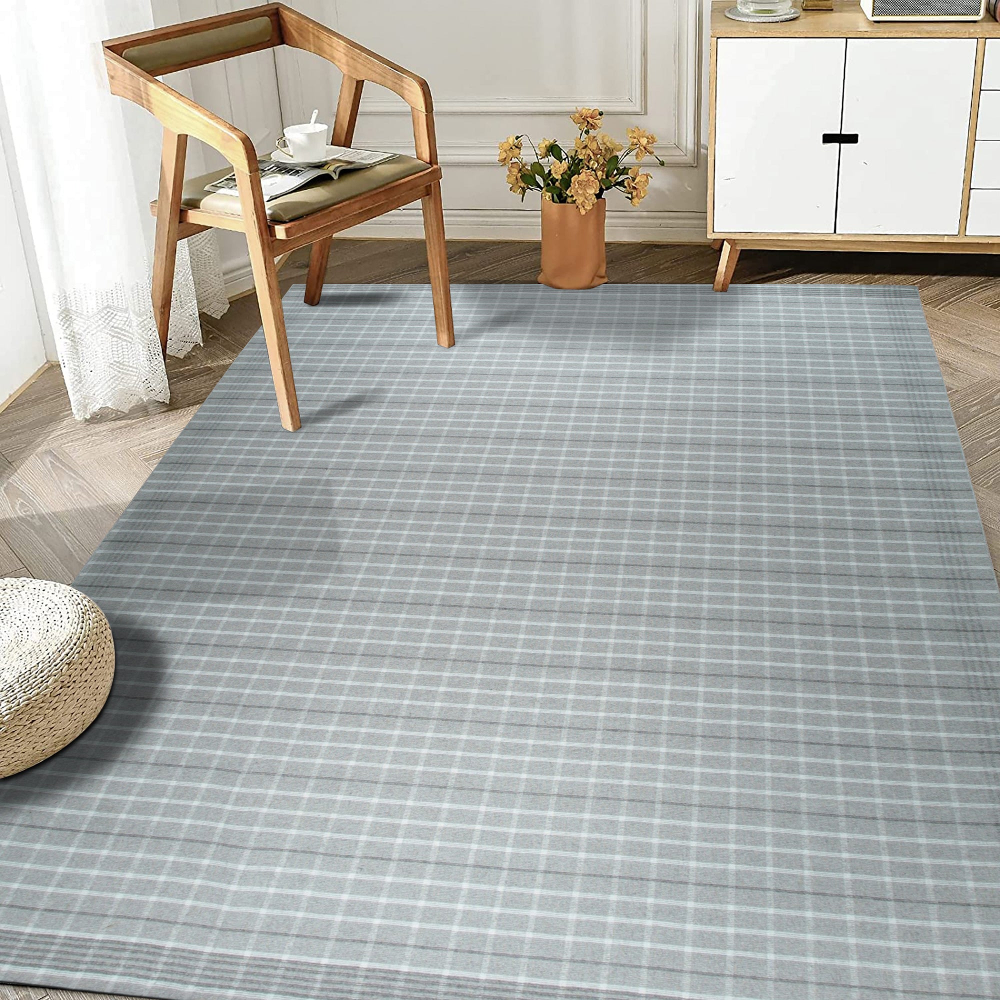 Timeless Celia Gray Flatweave Wool Rug, a soft gray wool rug with a subtle, geometric pattern, complementing a modern living room setting with light wood furniture and natural light.