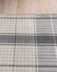 Lila Bianca Gray Flatweave Wool Rug, a calming gray and cream geometric pattern, adds understated elegance to a modern living room with minimalist furniture.