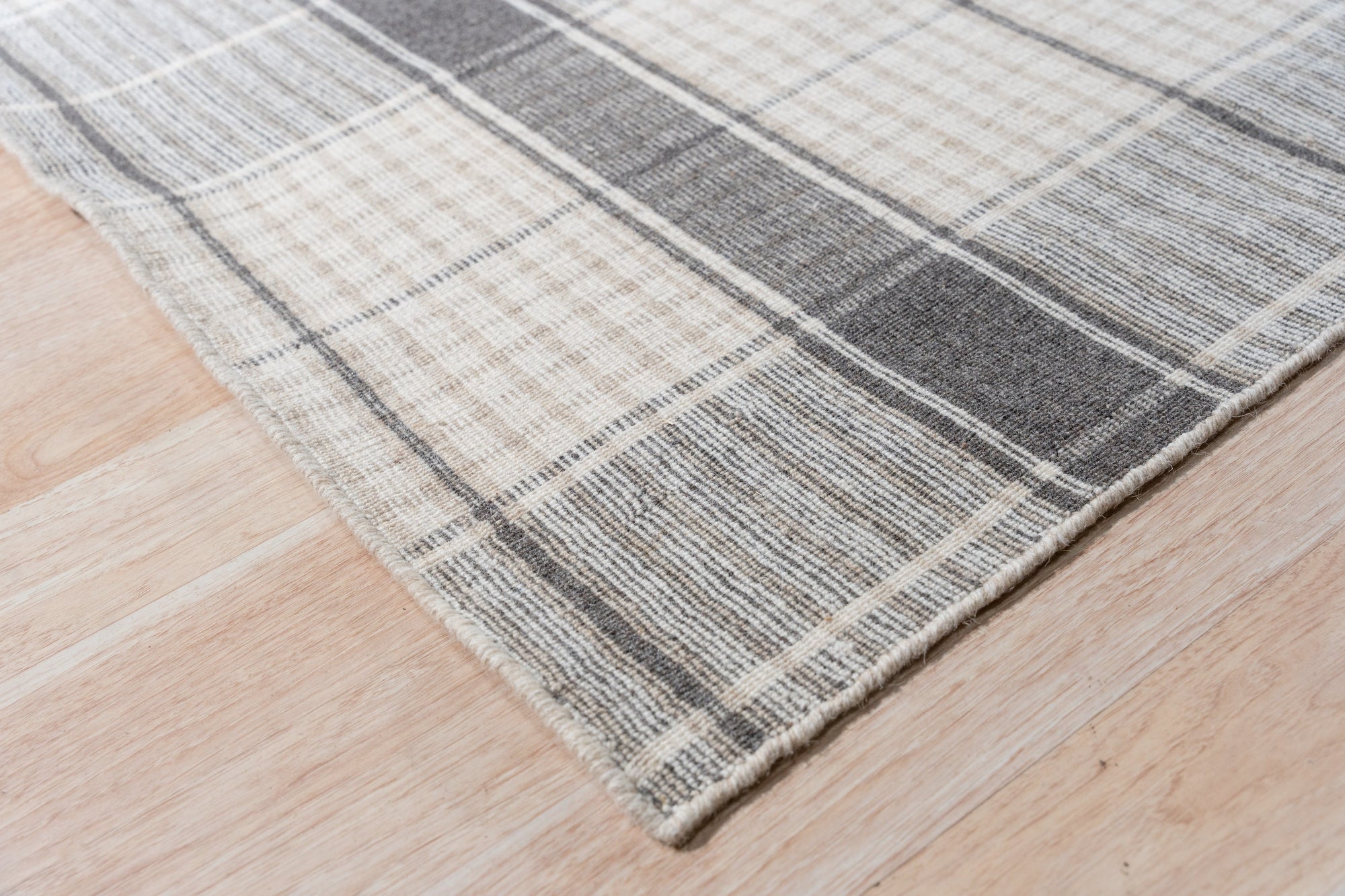 Lila Bianca Gray Flatweave Wool Rug, its subtle gray tones and flatweave construction displayed in a bright, inviting living space.
