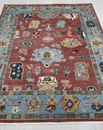 Mira Traditional Rust Hand Knotted Wool Rug, a richly colored accent anchoring a warm, inviting space, showcasing its detailed traditional pattern and handcrafted texture.