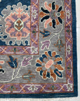 Unique Rustic Blue Hand Knotted Wool Rug, a richly textured wool rug with distressed blues and creams, lies flat, suggesting warmth and handcrafted quality.