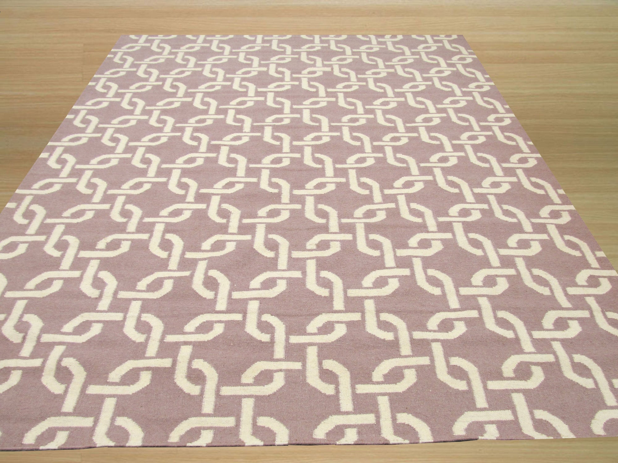Sloane Cozy Pink Flatweave Wool Rug, its soft pink hue warming a stylish living space. Subtle textures enrich the flatweave wool construction.