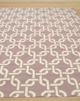 Sloane Cozy Pink Flatweave Wool Rug, its soft pink hue warming a stylish living space. Subtle textures enrich the flatweave wool construction.