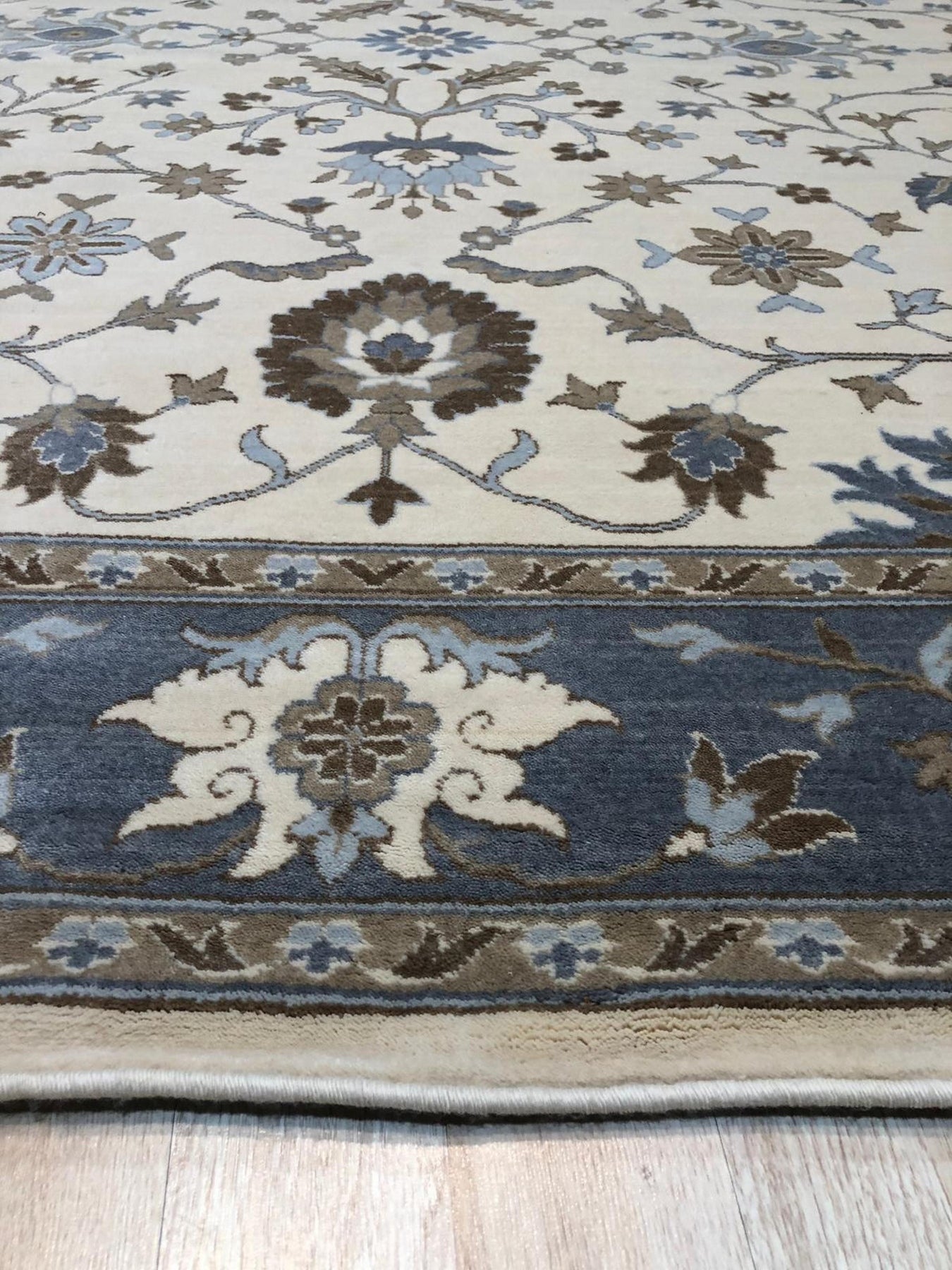 Opulent Oushak Ivory Hand Knotted Wool Rug, cream-colored wool rug with an intricate Oushak pattern, seen in a bright room setting.