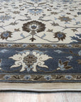 Opulent Oushak Ivory Hand Knotted Wool Rug, cream-colored wool rug with an intricate Oushak pattern, seen in a bright room setting.