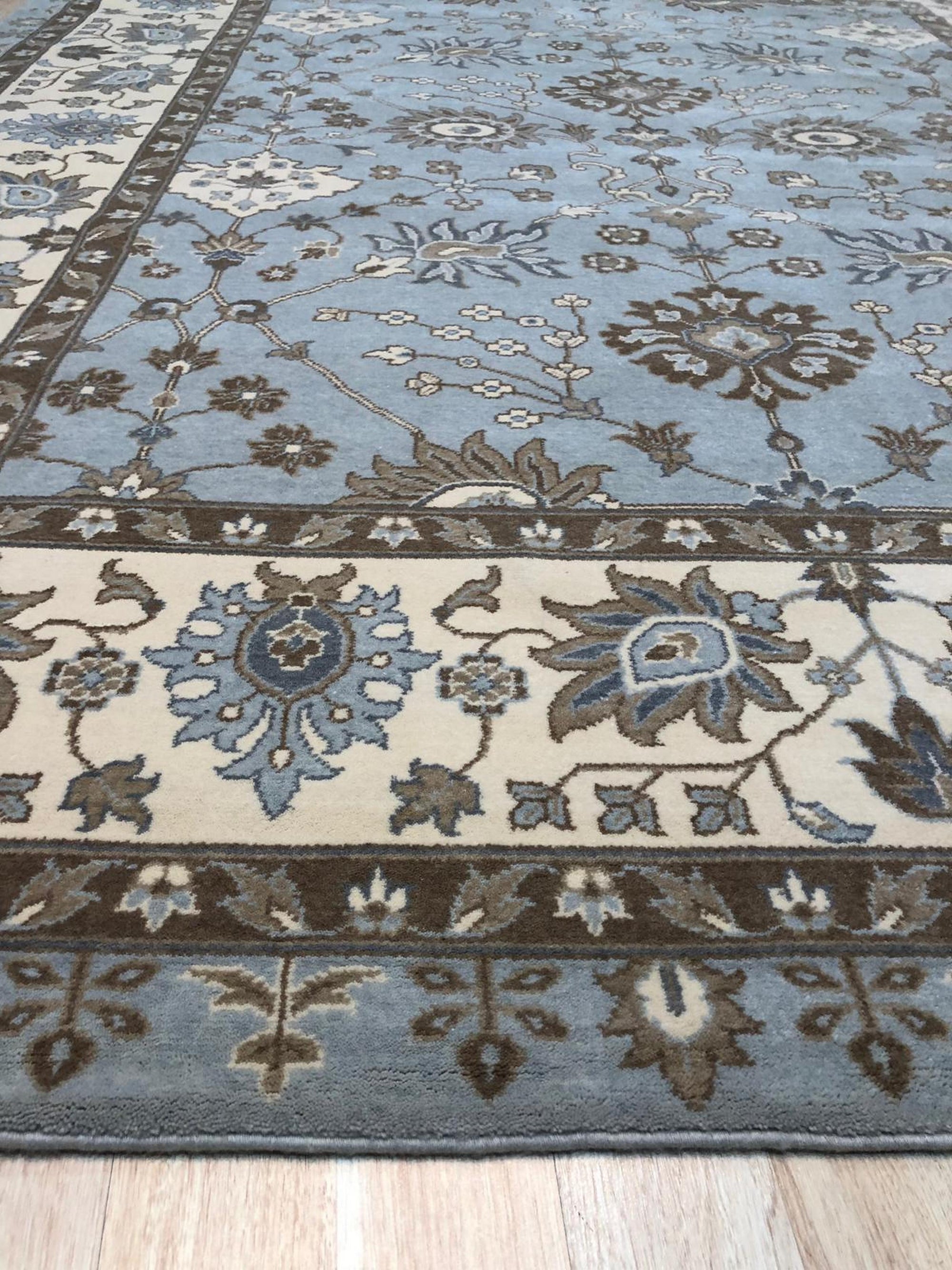 Artisan Oushak Light Blue Hand Knotted Wool Rug, showcasing a light blue palette and intricate Oushak design, softens a bright, sunlit room.