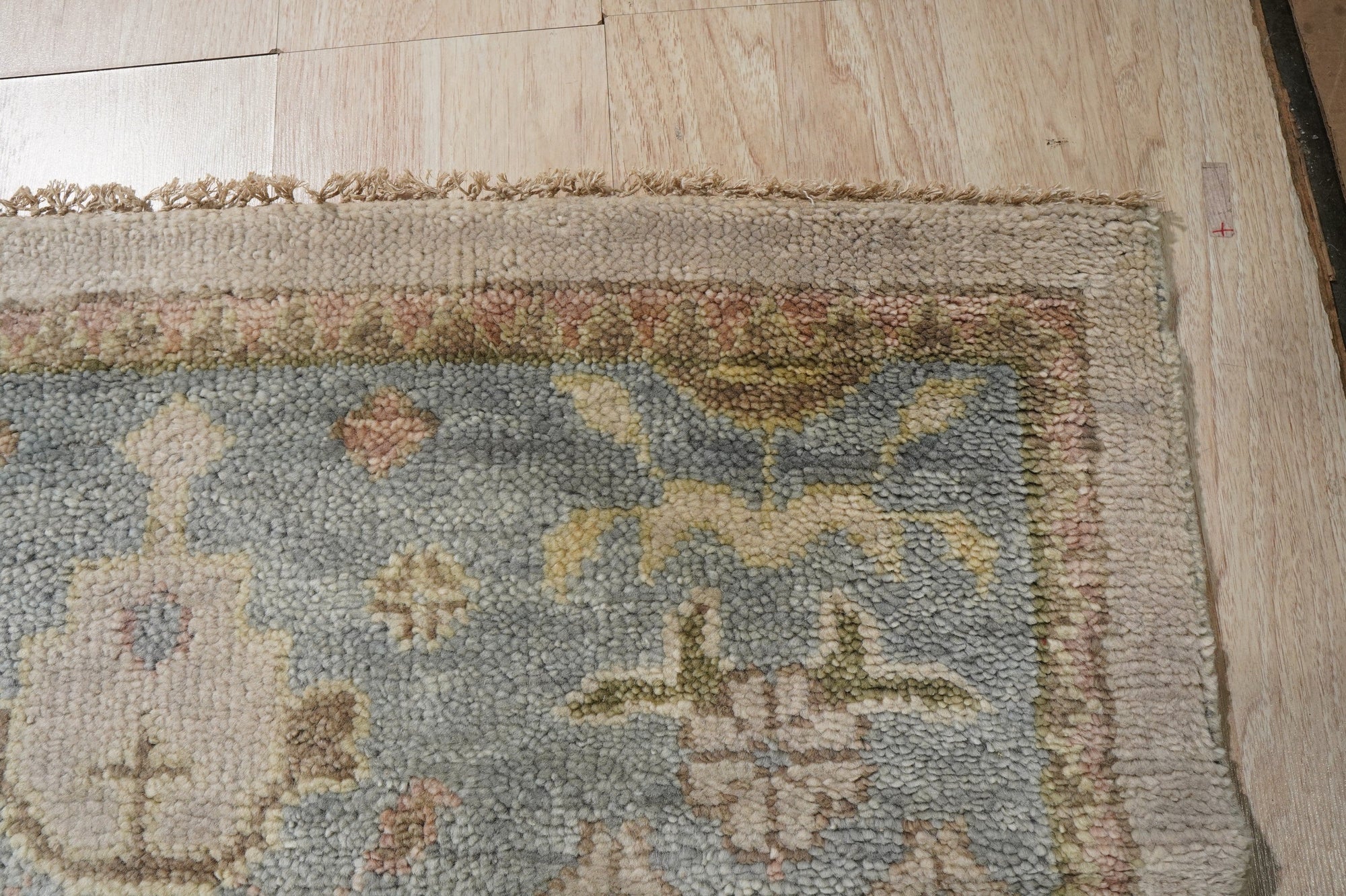 Classic Oushak Beige Hand Knotted Wool Rug displayed in a living room setting, its subtle beige tones complementing neutral furniture and creating a warm, inviting atmosphere.