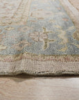 Classic Oushak Beige Hand Knotted Wool Rug displayed in a living room setting, its subtle beige tones complementing the surrounding furniture and lending warmth to the space.