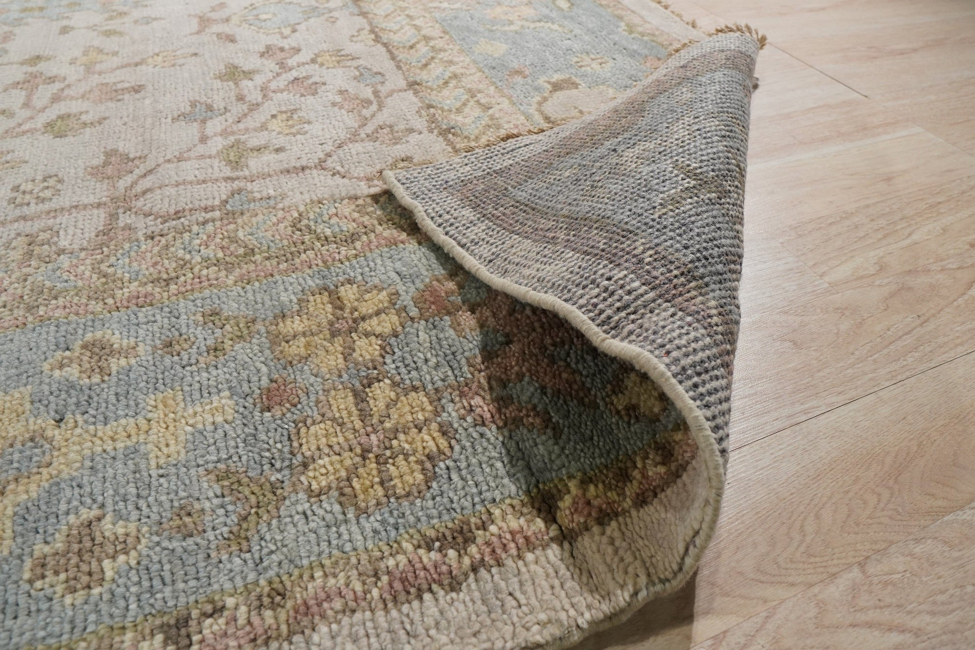 Classic Oushak Beige Hand Knotted Wool Rug, a beige wool rug hand-knotted with a traditional Oushak design, displayed in a bright living room setting.