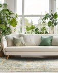 Freya Oushak Green Hand Knotted Wool Rug, exhibiting a detailed pattern in shades of green and cream, lies elegantly on a light wooden floor, enhancing a room with neutral walls and minimalist decor.
