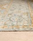Freya Oushak Green Hand Knotted Wool Rug, a verdant expanse of handcrafted wool featuring a traditional Oushak pattern, graces a warmly lit living space.