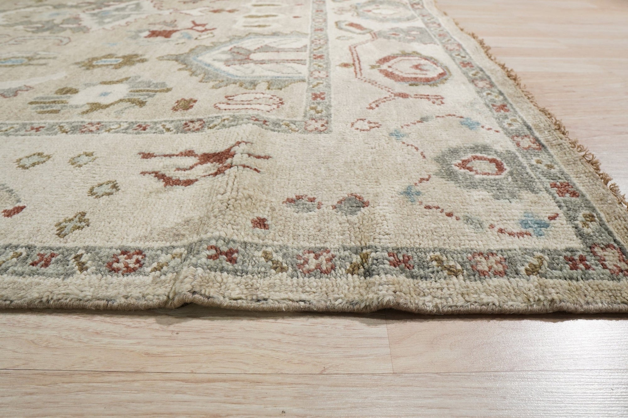 Versatile Oushak Ivory Hand Knotted Wool Rug, an ivory wool rug with a traditional Oushak design, seen in a living room setting, adding warmth and elegance to the space.