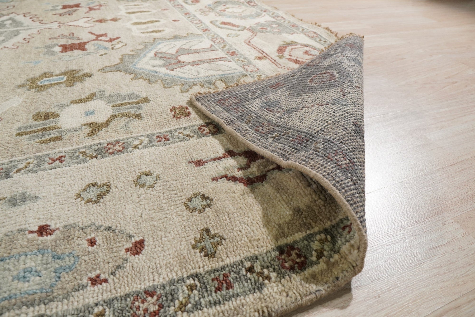 Here are a few options for alt text, considering the image position is 6:
 
 * Versatile Oushak Ivory Hand Knotted Wool Rug graces a bright living room, its soft ivory tones complementing the modern decor.
 
 * Hand-knotted wool rug, the Versatile Oushak Ivory, anchors a seating area with its subtle pattern and plush texture.
 
 * Ivory wool Versatile Oushak rug adds warmth and elegance to a home interior, showcasing its intricate knotting and classic design.