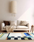 Celia Nadia Multicolor Flatweave Wool Rug in a bright living space, its flatweave construction displaying vibrant reds, blues, yellows, and greens across a geometric pattern.