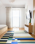Celia Nadia Multicolor Flatweave Wool Rug, vibrant hues dance across this flatweave wool rug, showcasing a geometric design in a modern living room setting.