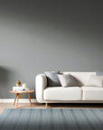 Captivating Talia Gray Handmade Wool Rug displayed on a light hardwood floor, its subtle gray tones and textured wool weave adding warmth to the modern interior.