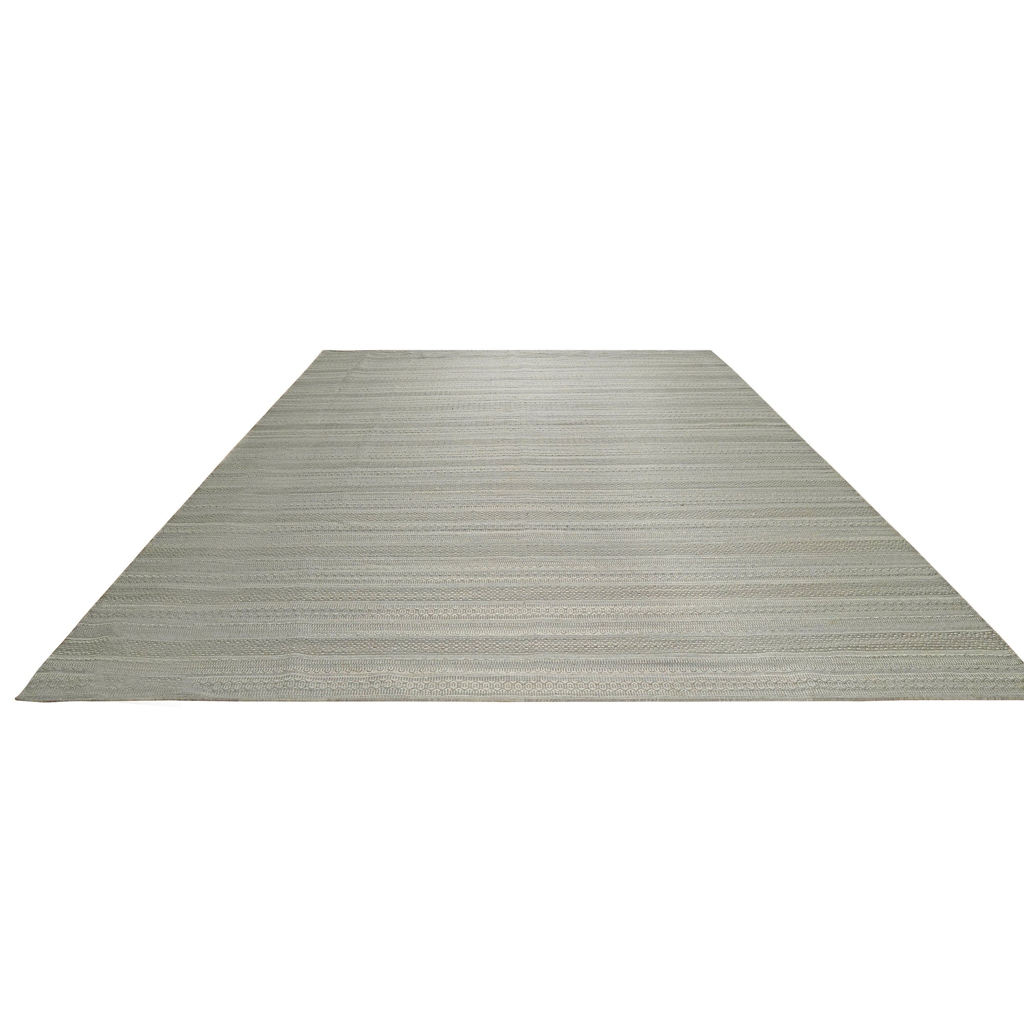 Captivating Talia Gray Handmade Wool Rug, a modern area rug featuring geometric patterns in shades of gray, beige, and cream, adding warmth to a living room setting with neutral furniture.