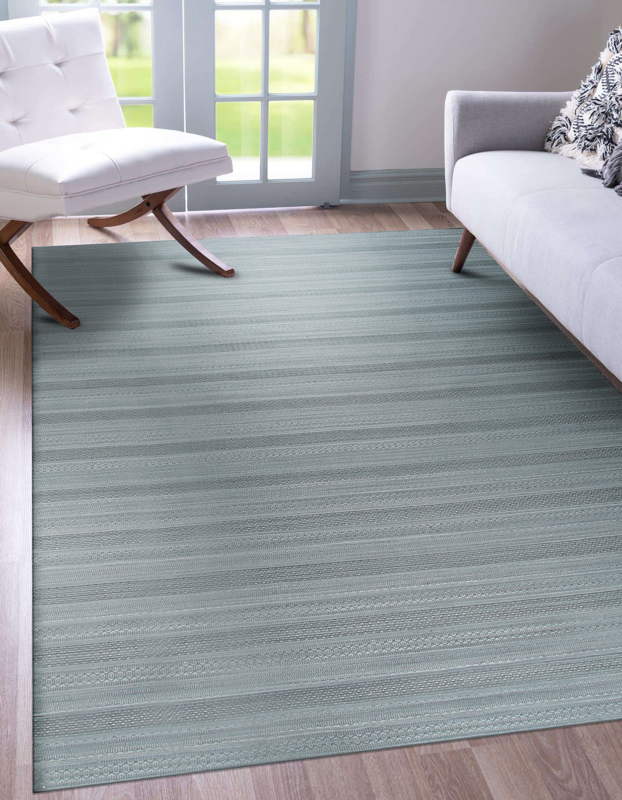 Captivating Talia Gray Handmade Wool Rug displayed in a warmly lit living room; its gray hues and hand-knotted construction complementing a neutral sofa and natural wood coffee table, creating a cozy and inviting atmosphere.