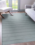 Captivating Talia Gray Handmade Wool Rug displayed in a warmly lit living room; its gray hues and hand-knotted construction complementing a neutral sofa and natural wood coffee table, creating a cozy and inviting atmosphere.