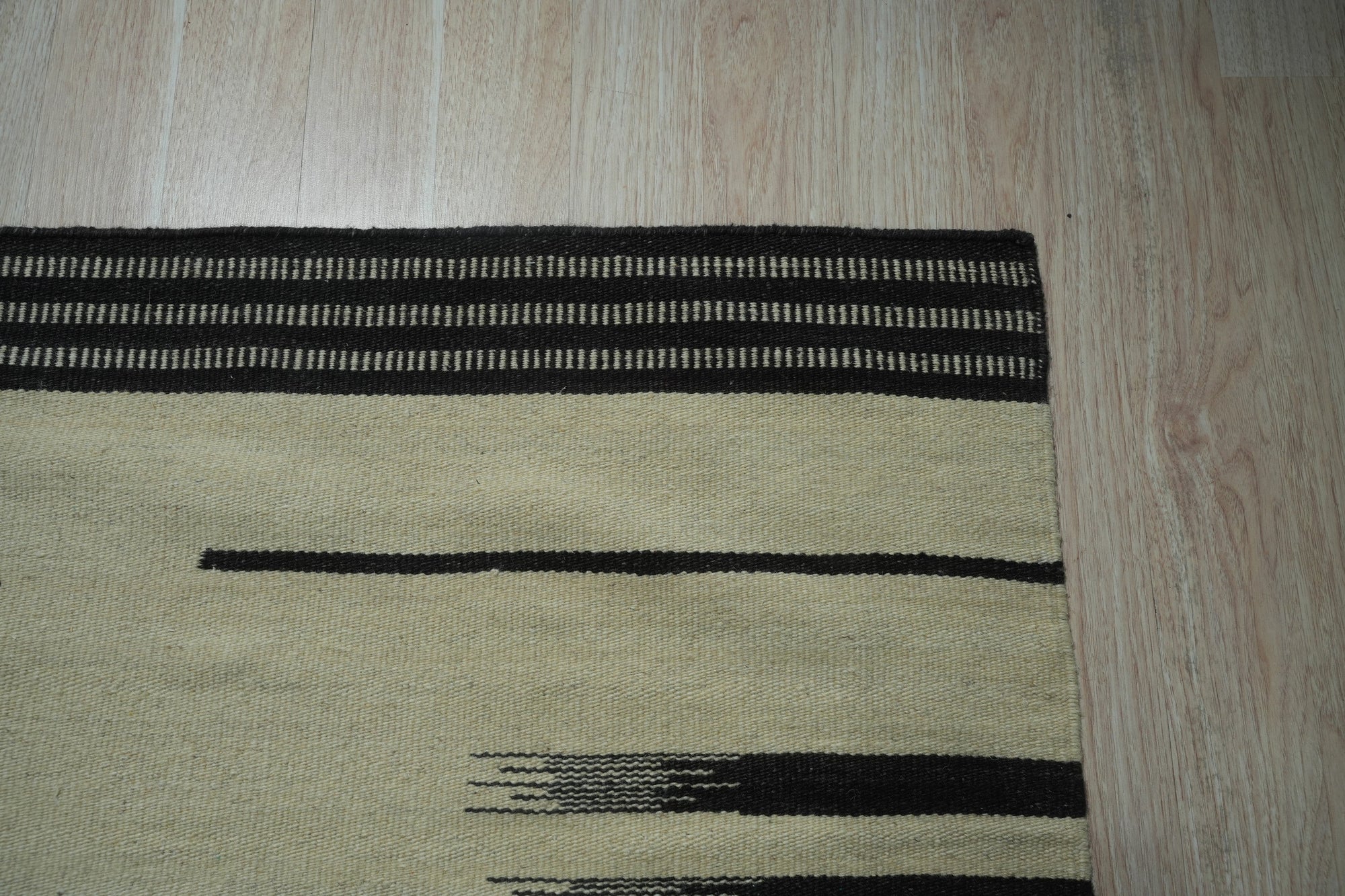 Sloane Majestic Gray Flatweave Wool Rug, a textured gray wool rug with subtle variations in tone, complements a light-filled living room with modern furniture.