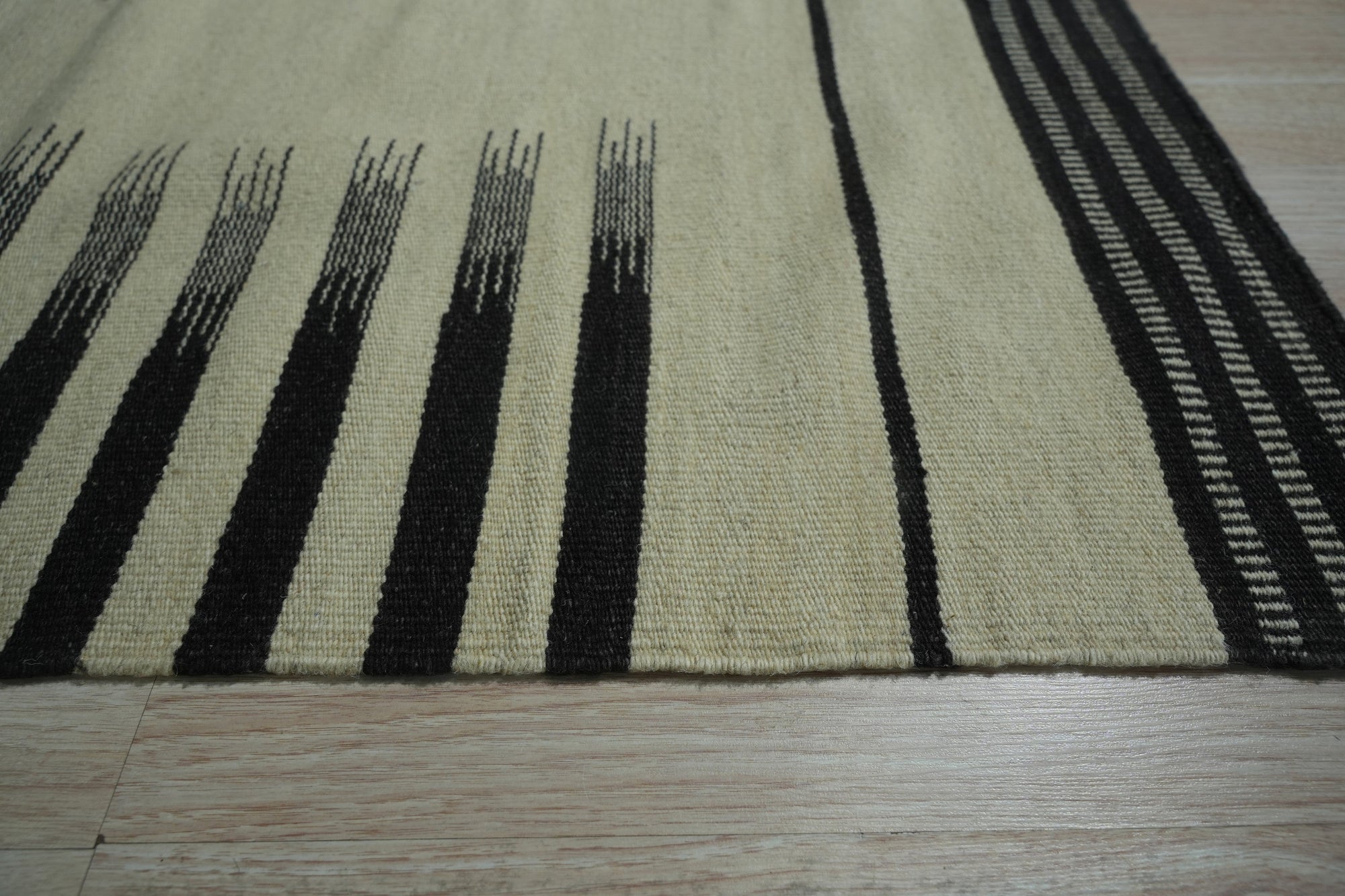 Sloane Majestic Gray Flatweave Wool Rug, offering a muted gray palette and flatweave construction, anchors a modern living room with layered textures and natural light.