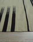 Sloane Majestic Gray Flatweave Wool Rug, offering a muted gray palette and flatweave construction, anchors a modern living room with layered textures and natural light.