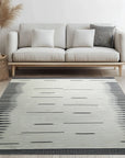 Sloane Majestic Gray Flatweave Wool Rug, a sophisticated and versatile gray wool rug with a subtle, textured flatweave, complementing a light and airy living room with modern furniture.