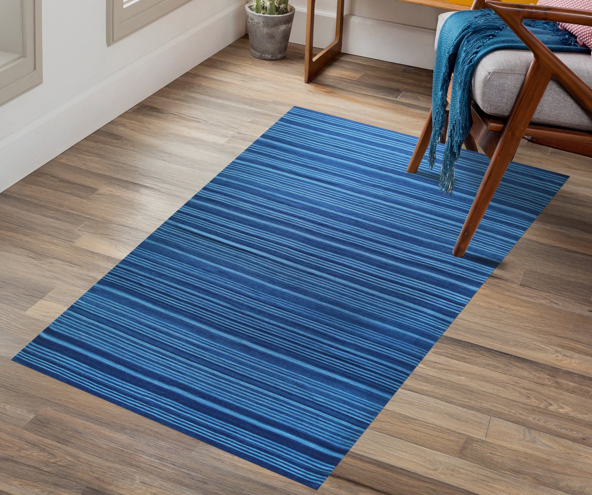 Para Penelope Blue Flatweave Wool Rug, showcasing its detailed geometric pattern in shades of blue and cream, elegantly complementing a contemporary living space with hardwood floors and neutral-toned furniture.