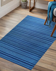 Para Penelope Blue Flatweave Wool Rug, showcasing its detailed geometric pattern in shades of blue and cream, elegantly complementing a contemporary living space with hardwood floors and neutral-toned furniture.