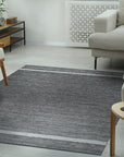 Cozy Inviting Gray Flatweave Wool Rug, blending seamlessly into a bright, modern living room with light wood floors and a neutral sofa. The flatweave construction is visible, adding subtle texture underfoot.