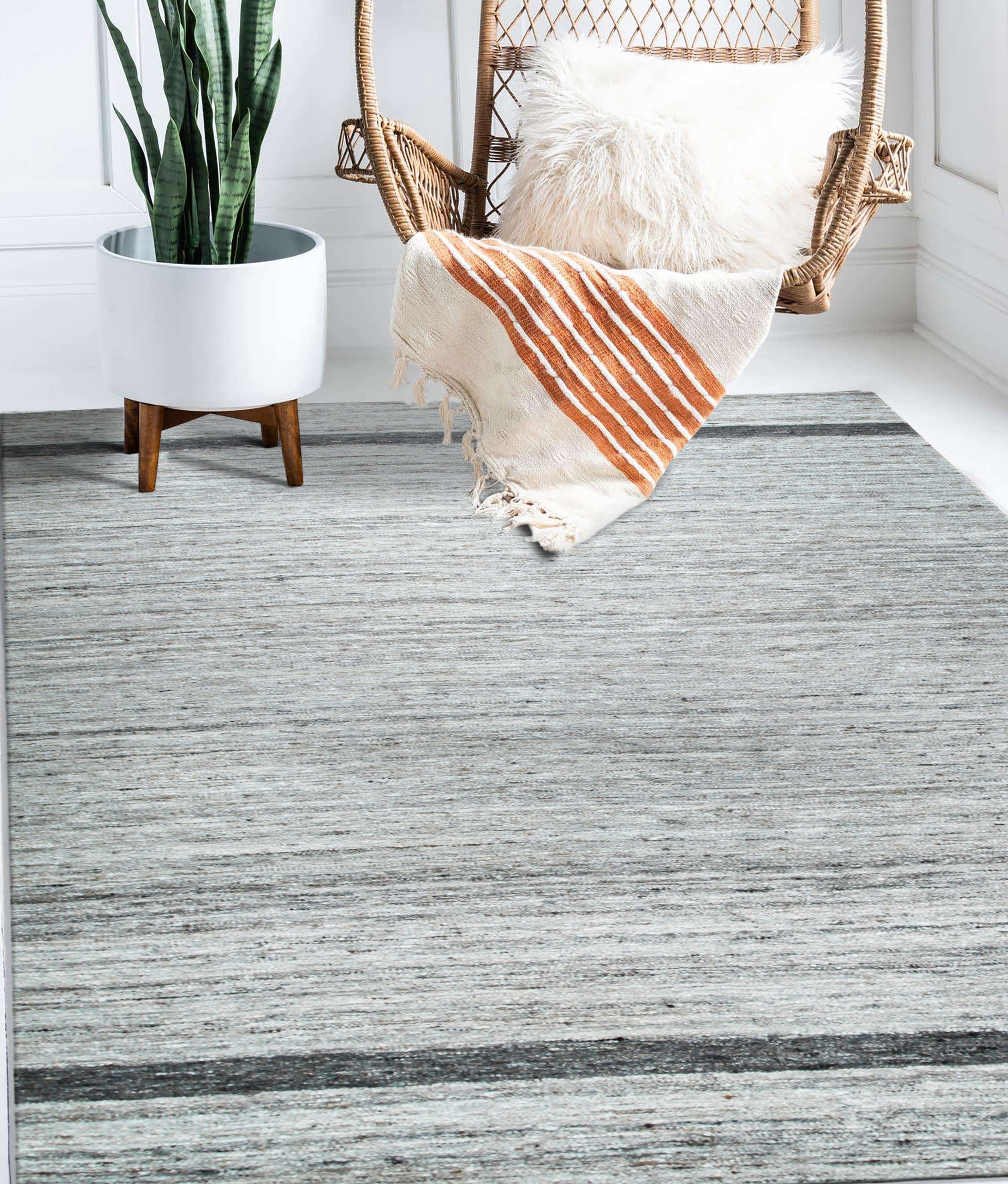 Lila Violet Light Gray Flatweave Wool Rug in a bright, minimalist living room setting; the rug's flatweave construction and subtle violet and light gray tones complement the modern decor.