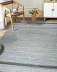 Lila Violet Light Gray Flatweave Wool Rug, featuring subtle gradations of color in a living room setting, adds a touch of serene sophistication to the space.