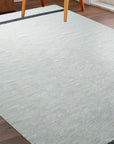 Artisan Nadia Ivory Flatweave Wool Rug anchors a bright, airy living room, its subtle texture complementing the modern décor. Natural light highlights the rug's creamy ivory hues and flatweave construction.