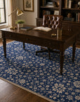 Blue ivory Oushak floral rug styled in a study with a writing desk