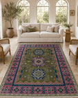 Green and fuchsia Kazak rug styled in a bright conservatory living room