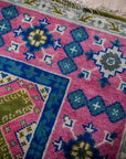 Green and fuchsia Kazak rug corner and fringe detail