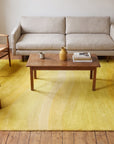 Inviting Ruby Yellow Hand Tufted Wool Rug in a living room
