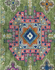 Green textured rug detail with a geometric medallion pattern in pink, blue, gray, and rust colors.
