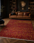 Red abstract sari-silk Anand rug in a moody library with leather sofa