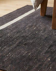 Charcoal Brown Artistic Flatweave Wool Rug in a bedroom